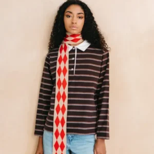 Model wearing TBCo Merino Wool Skinny Scarf in Red Harlequin with red and oatmeal diamond pattern and long slim fit