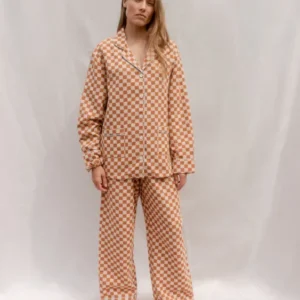 Woman wearing TBCo Cotton Pyjamas in Honey Checkerboard featuring breathable cotton and classic honey yellow pattern.