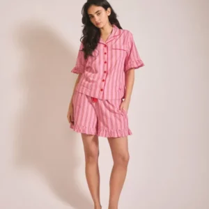 Woman wearing TBCo Cotton Pyjamas in Red Stripe Ruffle standing against plain background portrait orientation gallery 1