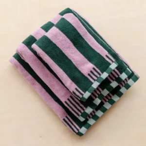 Stacked TBCo Terry Cotton Towels in Rose Stripe with pink and dark green stripes and checkerboard edges on wood surface