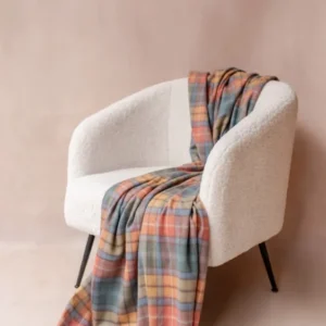 Soft TBCo Cashmere Blanket in Buchanan Antique Tartan draped over a white textured armchair with fringe detail